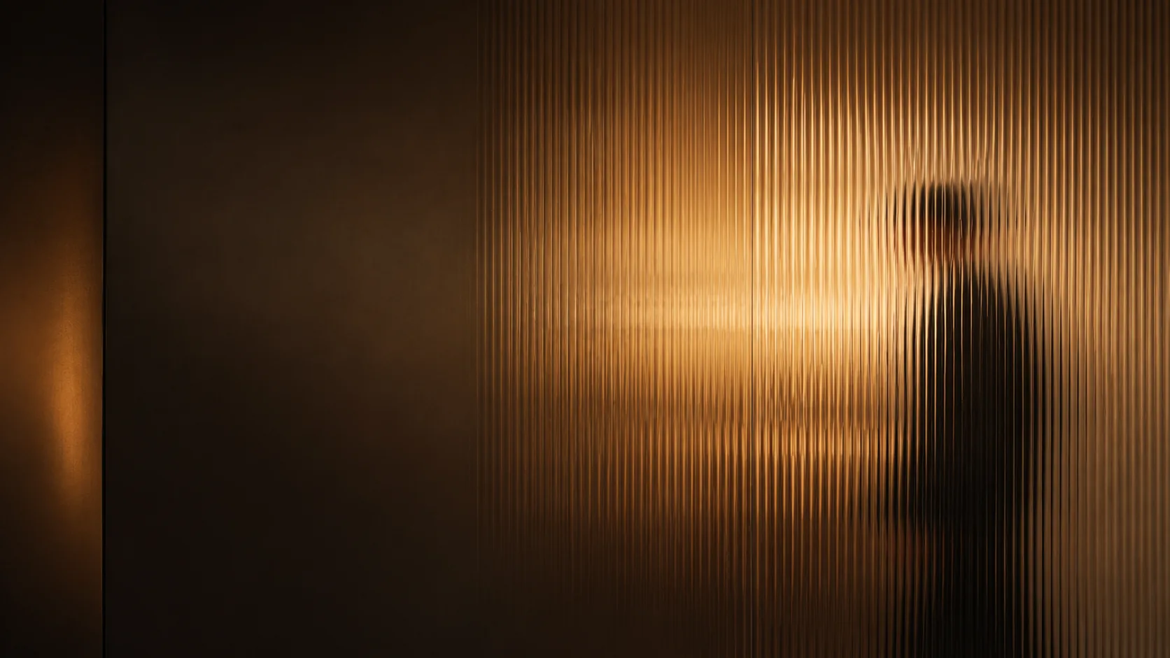 Low-lit fluted glass wall in a working office